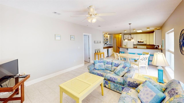 living room with sink and ceiling fan with notable chandelier