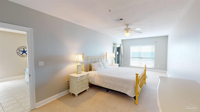 bedroom featuring ceiling fan, light carpet, and a textured ceiling