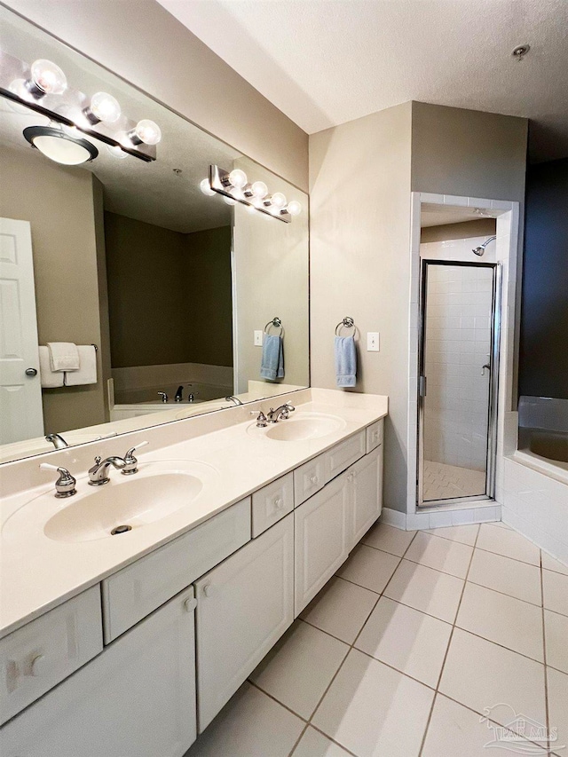 bathroom with vanity, a textured ceiling, shower with separate bathtub, and tile patterned floors