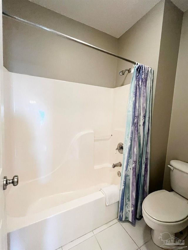 bathroom with toilet, tile patterned flooring, and shower / tub combo with curtain