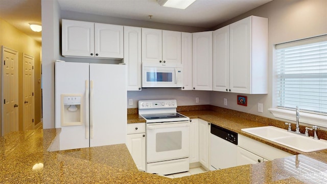 kitchen featuring white appliances, dark stone countertops, sink, and white cabinets