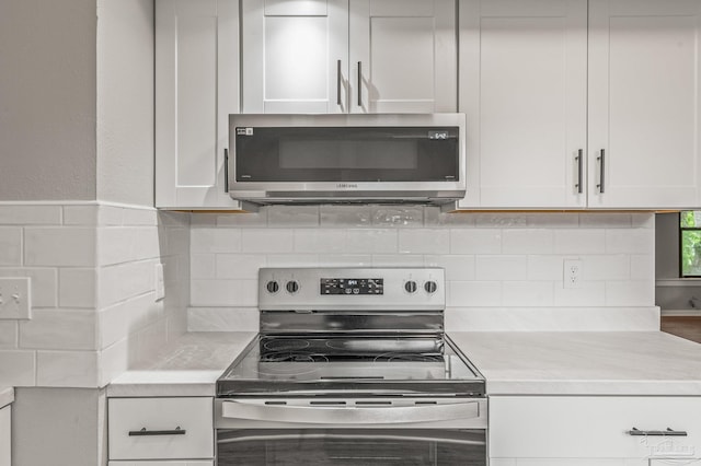 4905 State St, Pensacola, FL 32506 - kitchen featuring stainless steel appliances, light countertops, white cabinetry, and tasteful backsplash