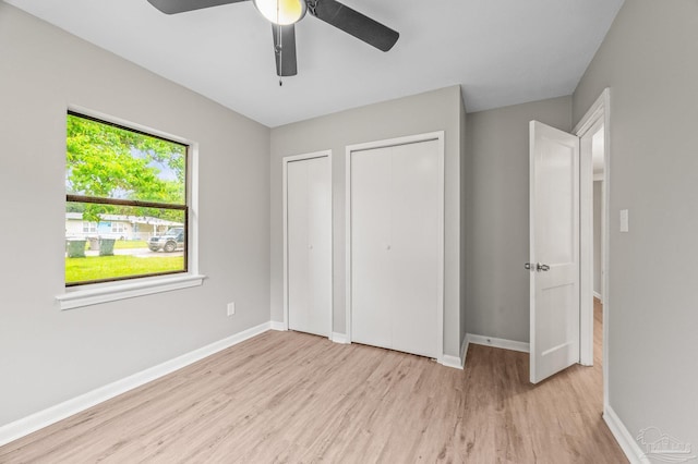 4905 State St, Pensacola, FL 32506 - unfurnished bedroom with wood finished floors, two closets, and baseboards