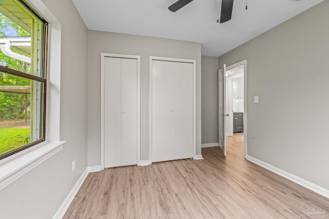 4905 State St, Pensacola, FL 32506 - unfurnished bedroom featuring light wood-style floors, two closets, baseboards, and a ceiling fan