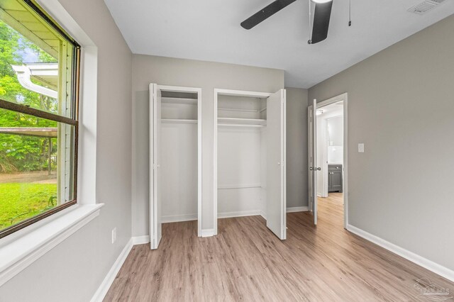 4905 State St, Pensacola, FL 32506 - unfurnished bedroom featuring two closets, light wood-type flooring, baseboards, and ceiling fan