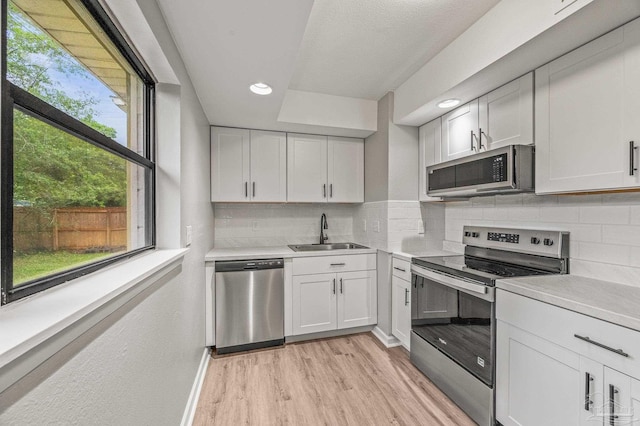 4905 State St, Pensacola, FL 32506 - kitchen featuring stainless steel appliances, a sink, light countertops, light wood-type flooring, and plenty of natural light