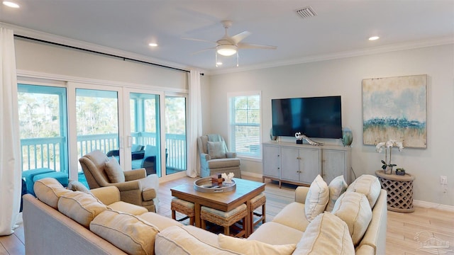 living room featuring ceiling fan, light wood-type flooring, and crown molding