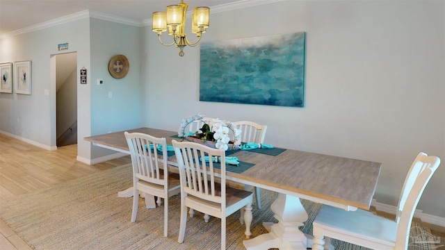 dining area featuring ornamental molding, light hardwood / wood-style floors, and a notable chandelier