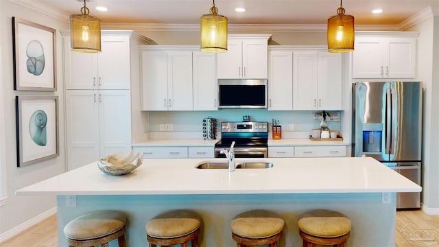 kitchen with a kitchen bar, appliances with stainless steel finishes, white cabinetry, and hanging light fixtures