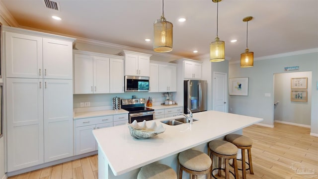 kitchen with white cabinetry, pendant lighting, stainless steel appliances, and sink