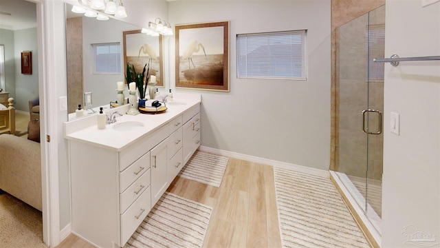 bathroom featuring hardwood / wood-style flooring, vanity, and walk in shower