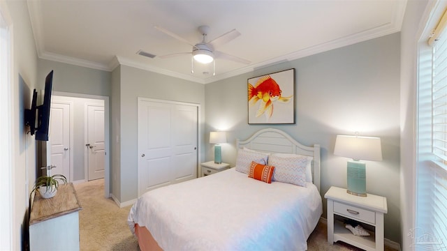 bedroom featuring crown molding, ceiling fan, a closet, and light colored carpet