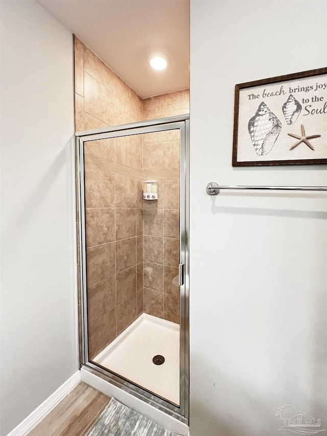 bathroom featuring hardwood / wood-style floors and a shower with door