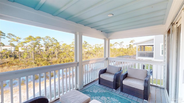 sunroom / solarium featuring beam ceiling and a healthy amount of sunlight