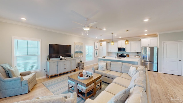 living room with ceiling fan, crown molding, and a healthy amount of sunlight