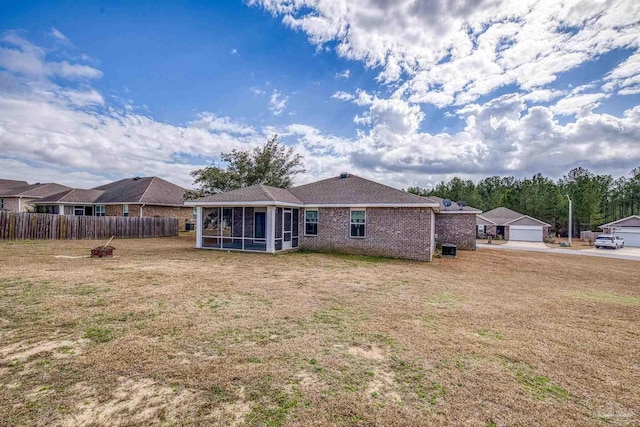 rear view of property with a lawn and a sunroom