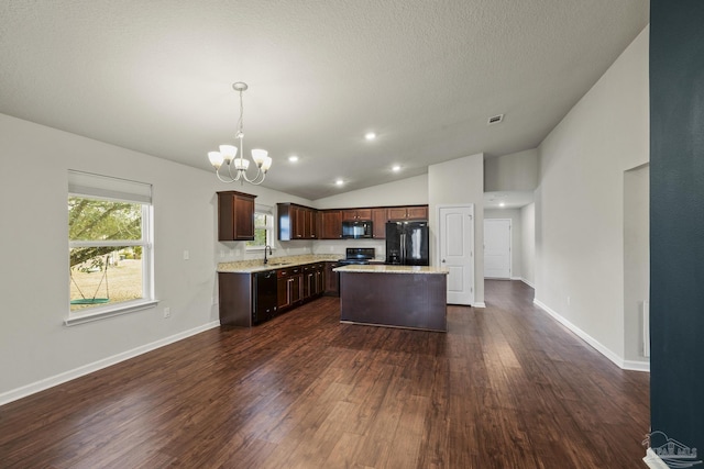 kitchen featuring sink, hanging light fixtures, a center island, a notable chandelier, and black appliances