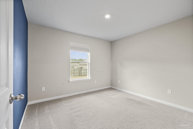 carpeted spare room featuring a textured ceiling