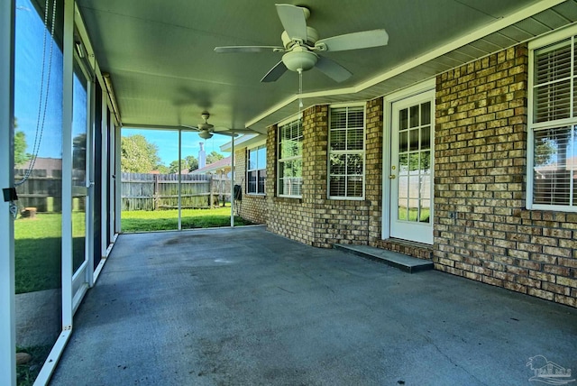 unfurnished sunroom featuring a ceiling fan