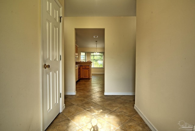 hall with tile patterned floors