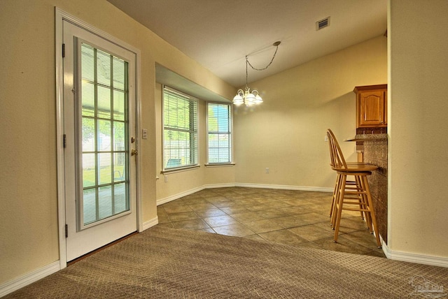 entryway featuring carpet flooring, lofted ceiling, and a notable chandelier