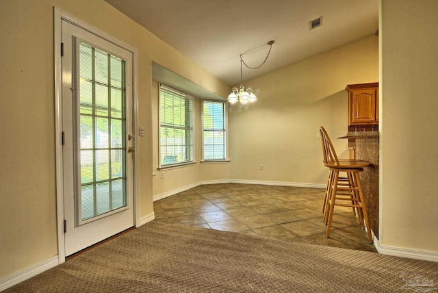 unfurnished dining area with vaulted ceiling, dark colored carpet, visible vents, and an inviting chandelier