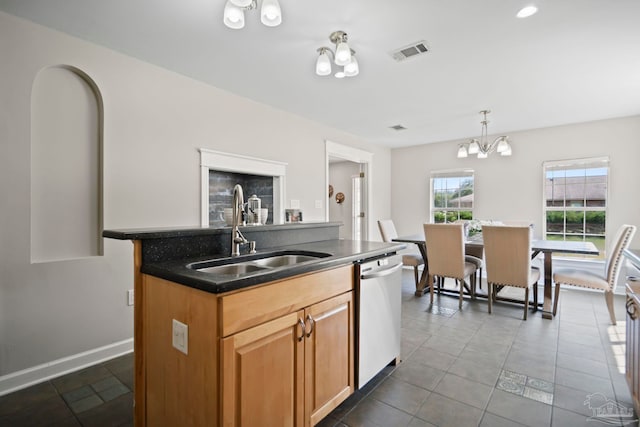 kitchen with sink, hanging light fixtures, stainless steel dishwasher, a chandelier, and a center island with sink