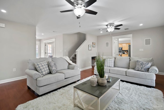 living room featuring dark hardwood / wood-style flooring and ceiling fan