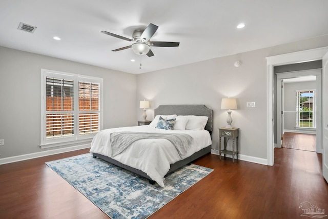 bedroom with dark hardwood / wood-style flooring and ceiling fan