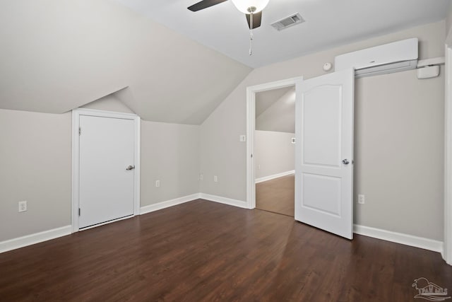 additional living space featuring ceiling fan, dark hardwood / wood-style flooring, lofted ceiling, and an AC wall unit