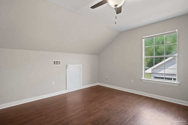 unfurnished bedroom with multiple closets, ceiling fan, dark wood-type flooring, and vaulted ceiling