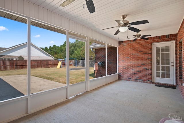 unfurnished sunroom featuring ceiling fan