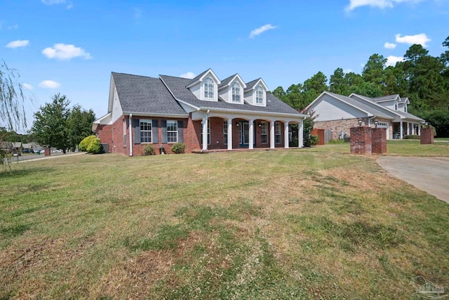 cape cod home with covered porch and a front yard