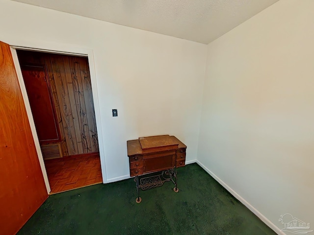 interior space with dark parquet flooring and a textured ceiling