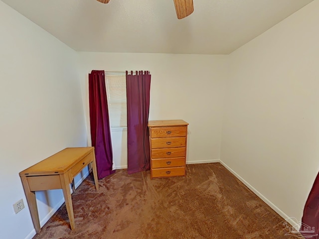 interior space with ceiling fan and dark carpet