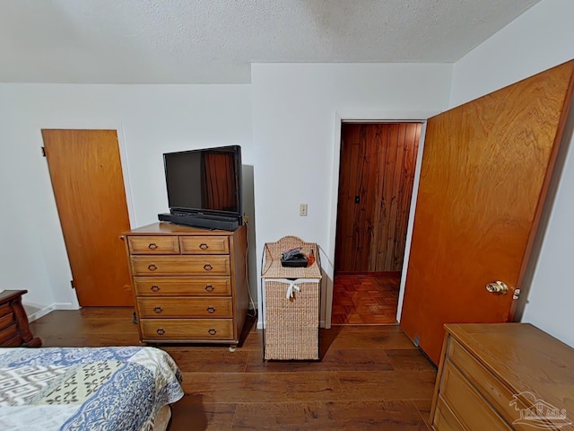 bedroom featuring dark hardwood / wood-style flooring, a textured ceiling, and a closet