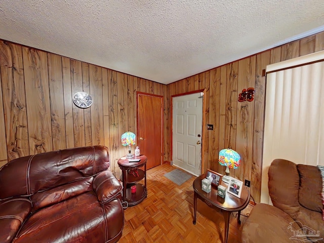 living room featuring a textured ceiling, wooden walls, and light parquet floors