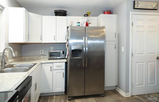 kitchen with white cabinets, appliances with stainless steel finishes, and dark hardwood / wood-style flooring