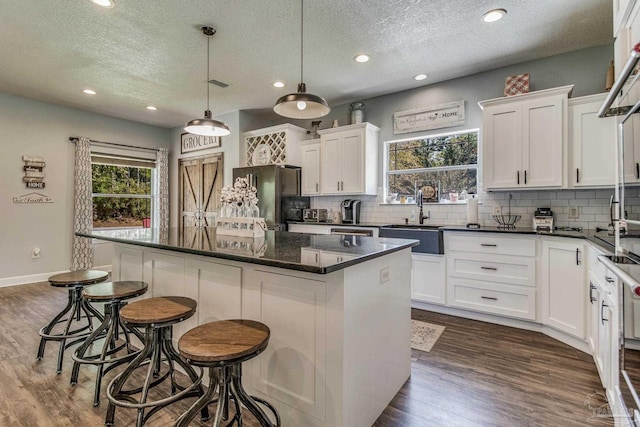 2685 Segrest Rd, Pace, FL 32571 - kitchen featuring a sink, freestanding refrigerator, plenty of natural light, a textured ceiling, and backsplash