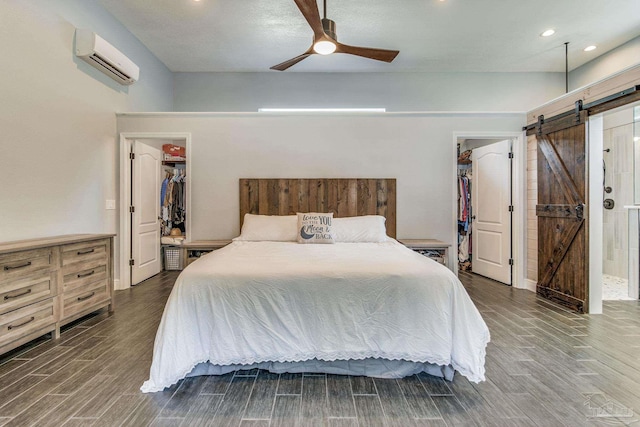 2685 Segrest Rd, Pace, FL 32571 - bedroom featuring a walk in closet, a closet, a wall mounted air conditioner, a barn door, and wood finish floors