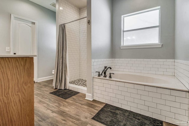 2685 Segrest Rd, Pace, FL 32571 - bathroom featuring a stall shower, a garden tub, and wood finished floors