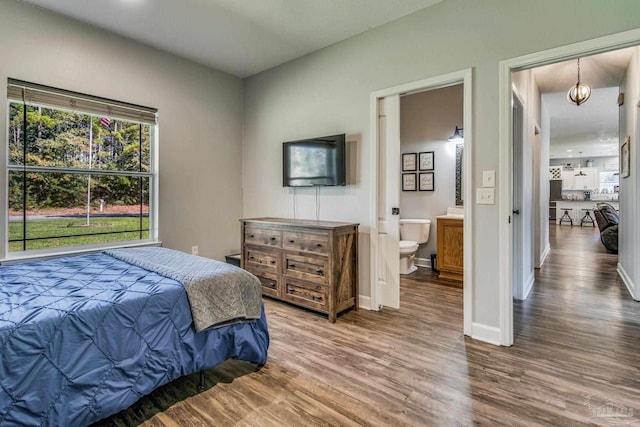 bedroom featuring ensuite bathroom and hardwood / wood-style floors