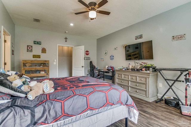 bedroom with hardwood / wood-style floors, a textured ceiling, and ceiling fan