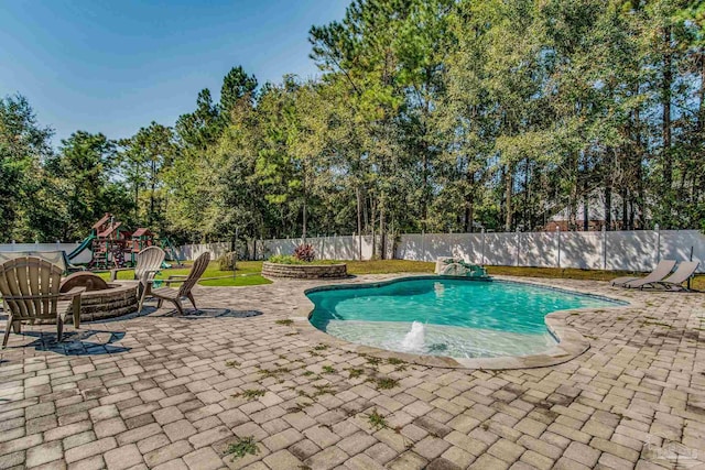 2685 Segrest Rd, Pace, FL 32571 - view of swimming pool featuring a patio area, a playground, a fenced backyard, an outdoor fire pit, and view of scattered trees