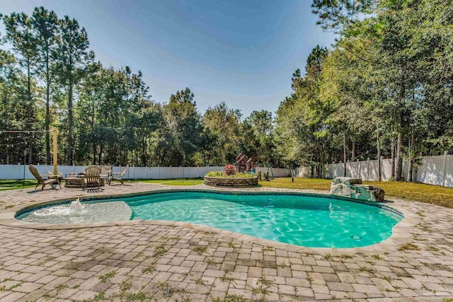 view of pool with pool water feature, a yard, and a patio