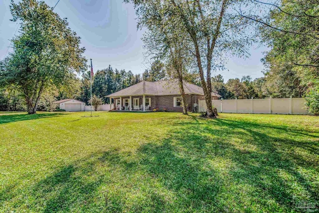 view of yard with a garage and an outbuilding