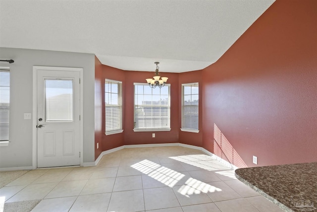 unfurnished dining area with light tile patterned flooring and an inviting chandelier