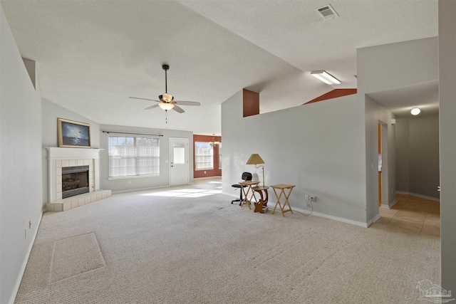 unfurnished living room featuring ceiling fan, a fireplace, light carpet, and lofted ceiling