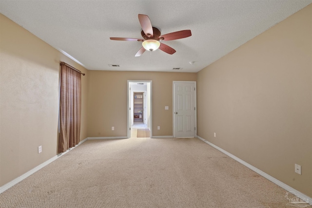 carpeted empty room featuring ceiling fan and a textured ceiling