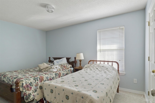 bedroom featuring a textured ceiling and light carpet